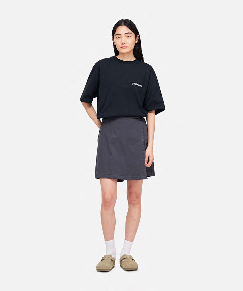 Model wearing a Gramicci G-Skort in the color fossil grey and a black shirt on a light-tone background.