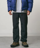 Model wearing black Nylon Gramicci Pants and a blue jacket on a light-tone background.
