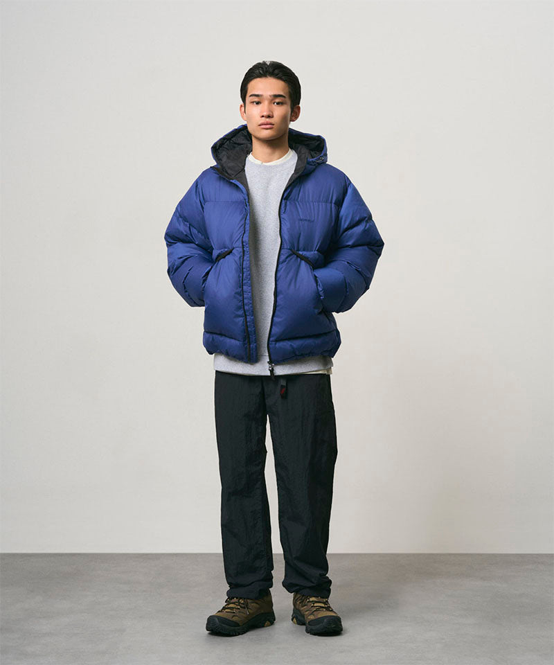 Model wearing black Nylon Gramicci Pants and a blue jacket on a light-tone background.