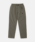 Burnt olive colored Nylon Gramicci Pants with a belt against a light-tone background.