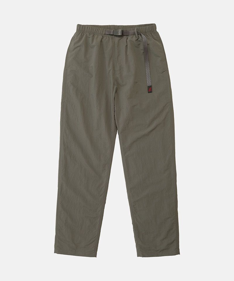 Burnt olive colored Nylon Gramicci Pants with a belt against a light-tone background.