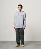 Model wearing carbon colored Nylon Gramicci Pants and a grey hoodie on a light-tone background.