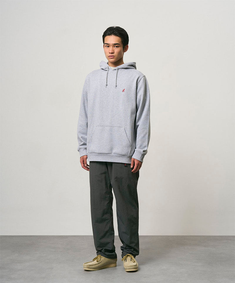 Model wearing carbon colored Nylon Gramicci Pants and a grey hoodie on a light-tone background.