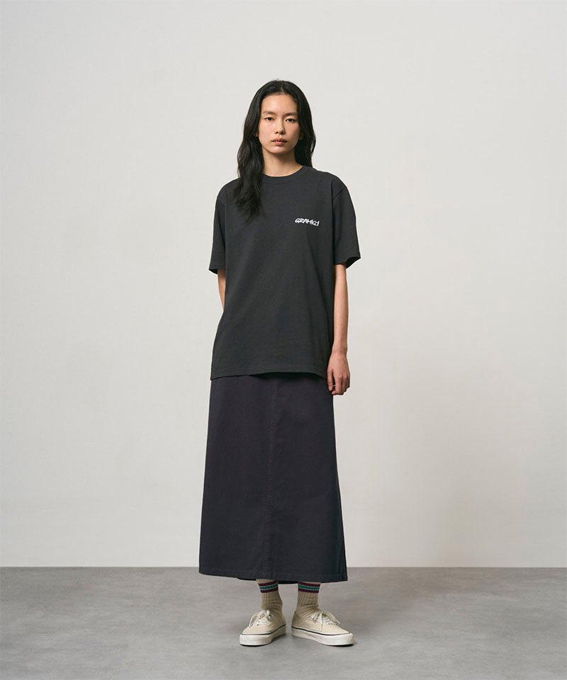 Model wearing a vintage black Gramicci Bass Tee and black skirt on a light-tone background.