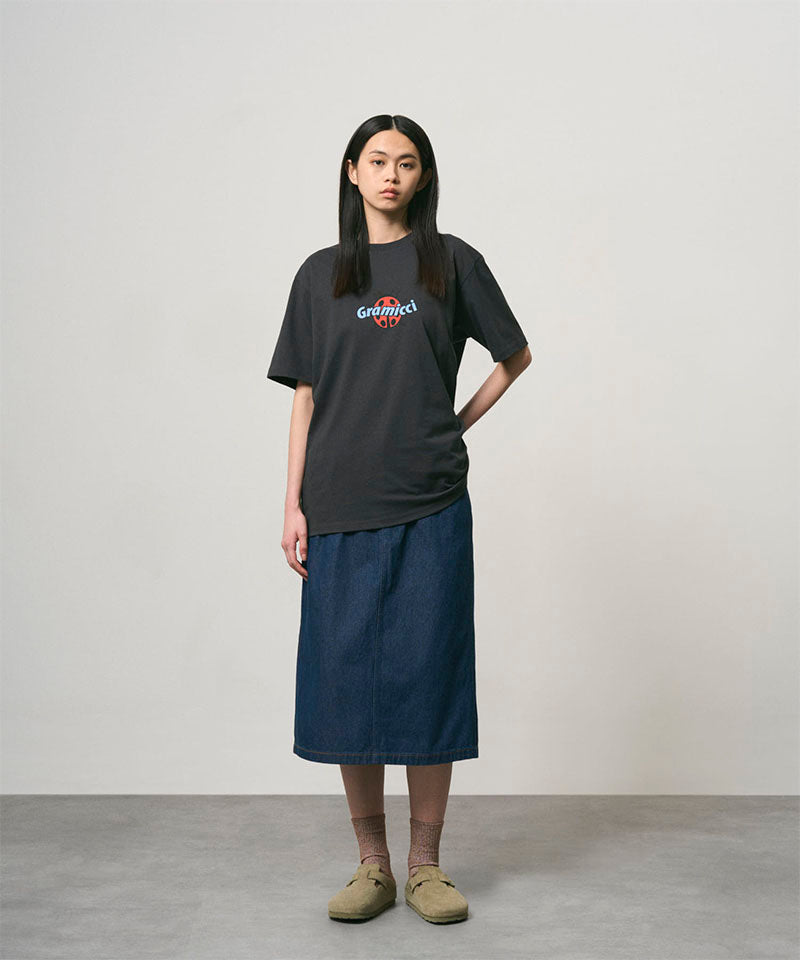 Model wearing a vintage black Gramicci Ladybug Tee with colorful graphic and blue skirt on a light-tone background.