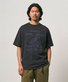 Model wearing a Gramicci vintage black Yosemite Valley Tee with a graphic against a light-tone background.