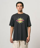 Model wearing a Gramicci vintage black Starburst Tee with a graphic against a light-tone background.