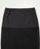 Back view close-up of a black Gramicci Thermal Fleece Skirt against a light-tone background.