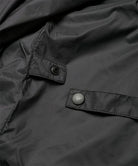 Close-up view of a black Gramicci Thermal Fleece Skirt against a light-tone background.