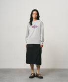 Model wearing a black Gramicci Thermal Fleece Skirt and a grey sweatshirt on a light-tone background.