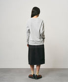 Model wearing a black Gramicci Thermal Fleece Skirt and a grey sweatshirt on a light-tone background.