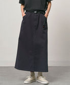 Model wearing a double navy Gramicci 5-Pocket Skirt and a black shirt on a light-tone background.