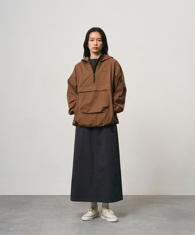 Model wearing a double navy Gramicci 5-Pocket Skirt and a brown jacket on a light-tone background.