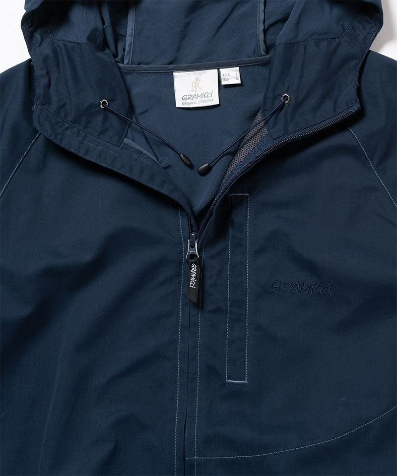 Close-up of a dark navy Gramicci Milton Hooded Jacket on a light-tone background.