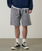 Model wearing a Gramicci Natural Dyed Jam Short in the color grey on a light-tone background.
