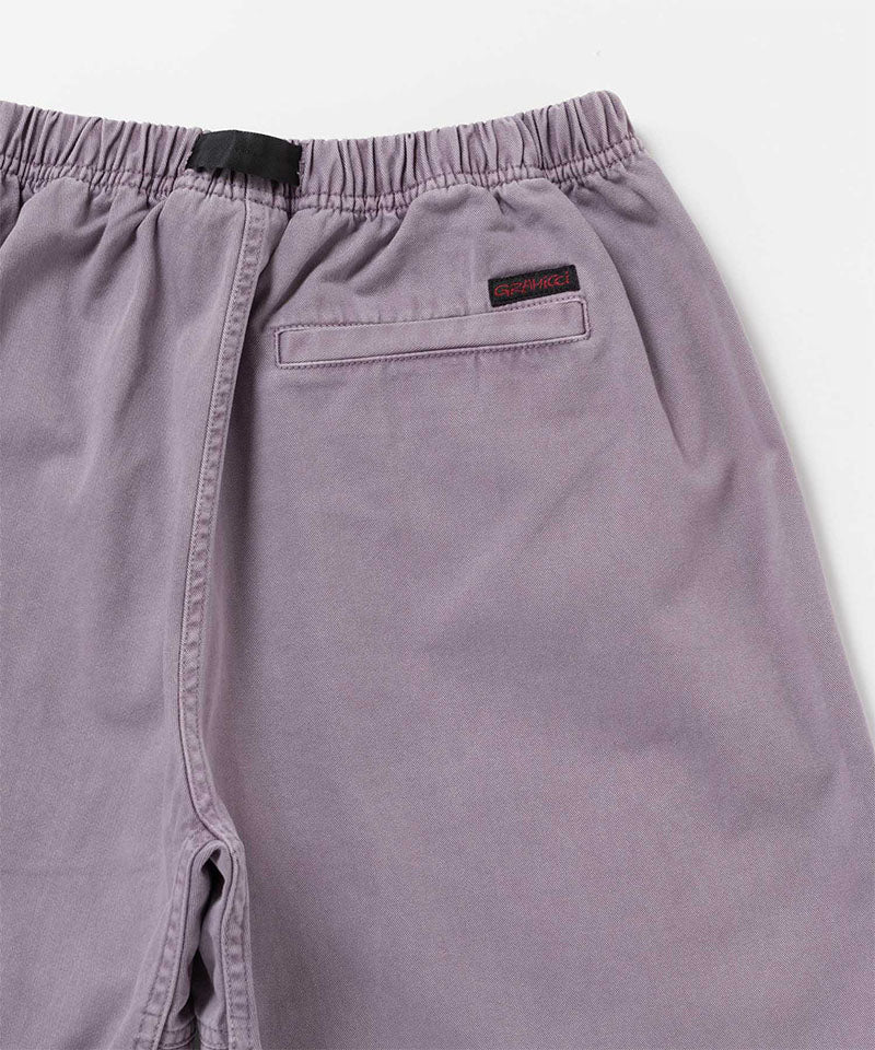 Back view close-up of Gramicci Natural Dyed Jam Short in the color purple against a light-tone background.
