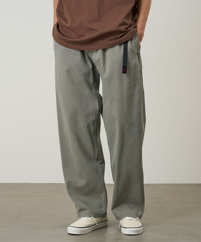 Model wearing a Natural Dyed Gramicci Pant Straight Fit in the color olive on a light-tone background.
