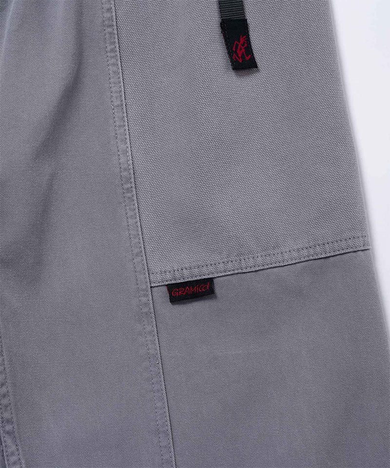 Close-up of natural dyed grey Gramicci Gadget Pants on a light-tone background.

