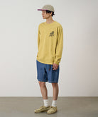 Model wearing blue Gramicci Japanese Chambray Shorts and a yellow shirt on a light-tone background.