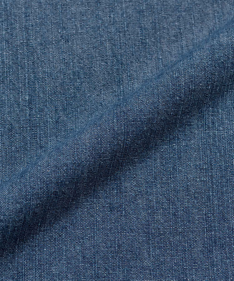 Close-up of Gramicci Japanese Chambray Double Knee pant blue denim fabric with a subtle pattern.
