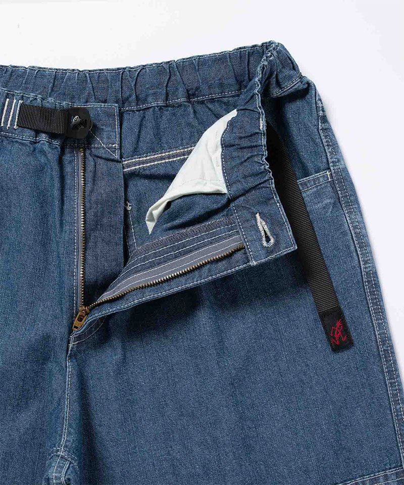 Close-up of the blue Gramicci Japanese Chambray Double Knee pant showing the zIp fly and belt on a light tone background.
