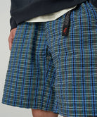 Model wearing a Gramicci blue multistripe Gramicci O.G. G-Short Seersucker Plaid against a light-tone background.