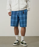 Model wearing a Gramicci indego Lagoon Short Denim Plaid against a light-tone background.