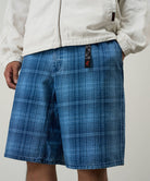 Model wearing a Gramicci indego Lagoon Short Denim Plaid against a light-tone background.