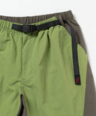 Close-up view of jade green Gramicci Nylon Block Shorts on a light-tone background.