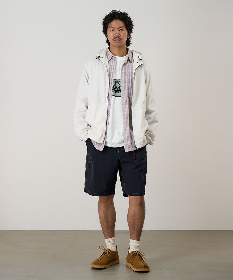 Model wearing black Gramicci Nylon Cliff Short and a white jacket on a light-tone background.