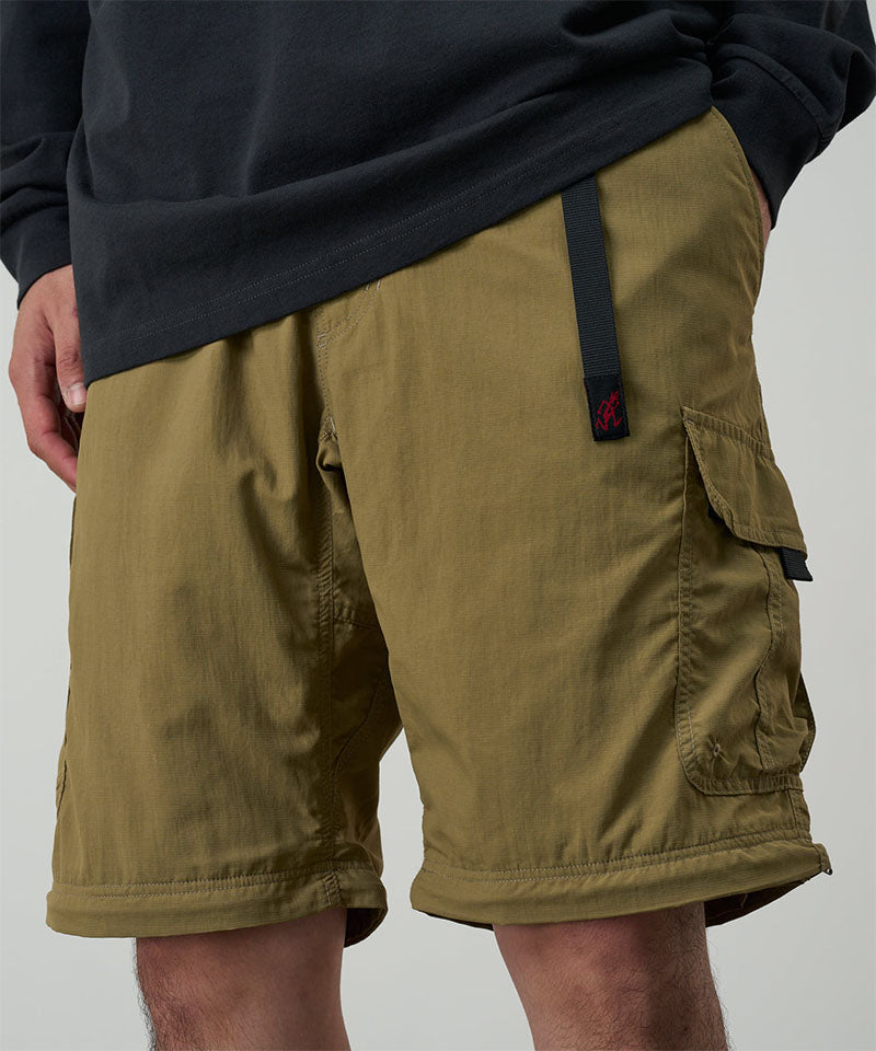 Model wearing khaki Gramicci Convertible Cargo Pants and a black shirt on a light-tone background.