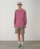 Model wearing brick check colored Gramicci Checkered Shell Shorts and a red shirt on a light-tone background.