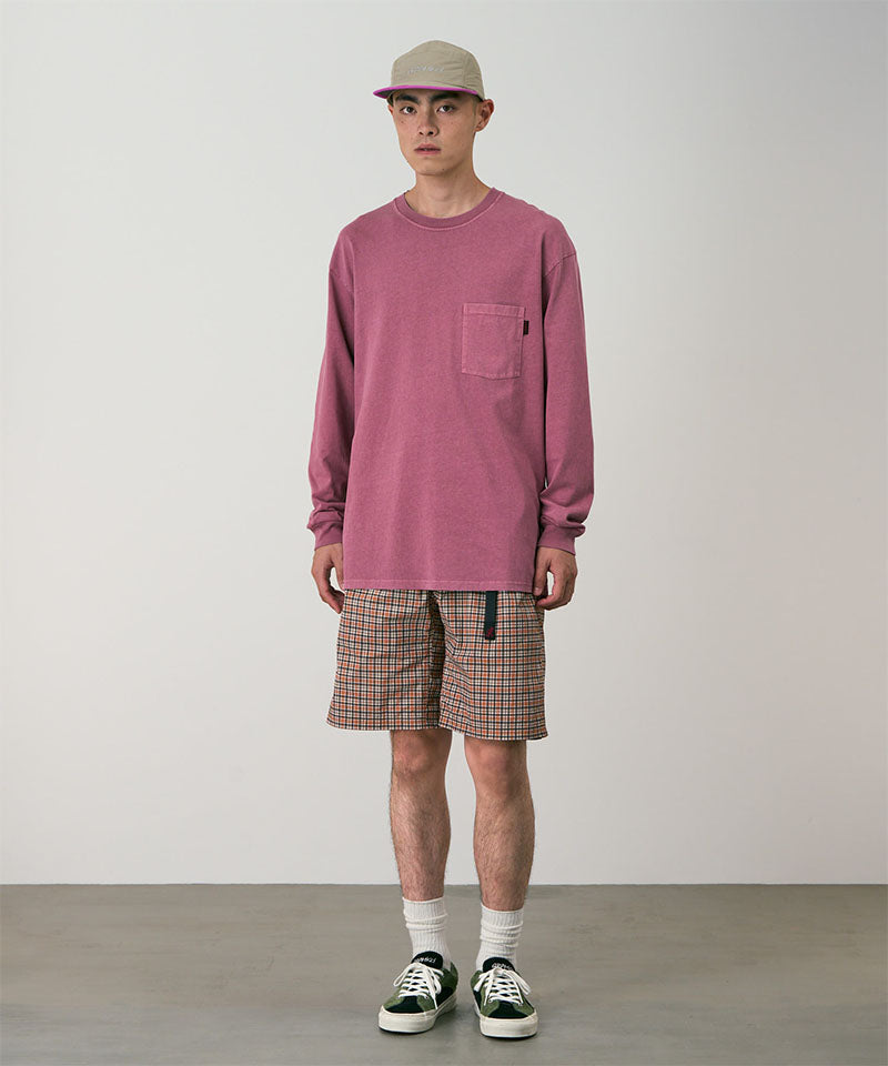 Model wearing brick check colored Gramicci Checkered Shell Shorts and a red shirt on a light-tone background.
