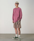 Model wearing brick check colored Gramicci Checkered Shell Shorts and a red shirt on a light-tone background.