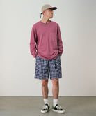 Model wearing navy check colored Gramicci Checkered Shell Shorts and a red shirt on a light-tone background.