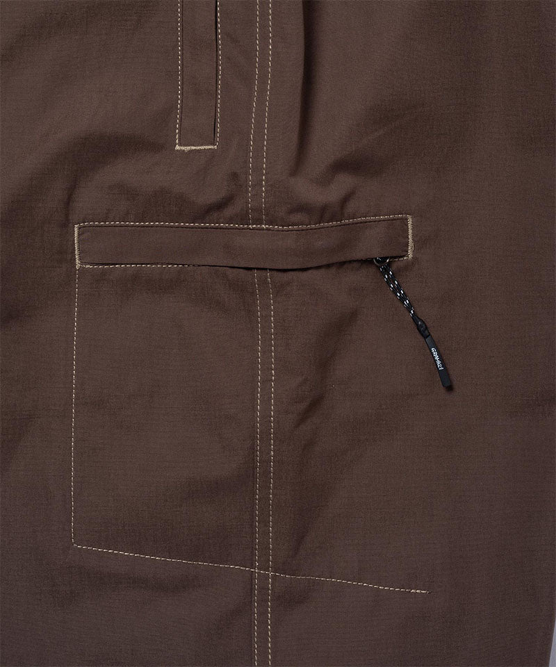 Close-up of Gramicci Milton Pants in the color walnut against a light-tone background.