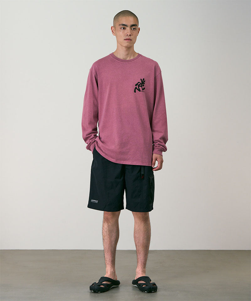 Model wearing black Gramicci Guide Shorts and a red shirt on a light-tone background.
