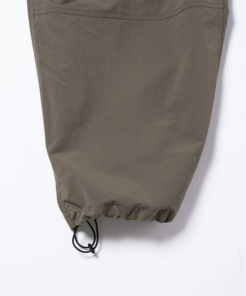 Granite colored Gramicci Nylon Paneled Trek Pants hem with drawstring on a light-tone background.