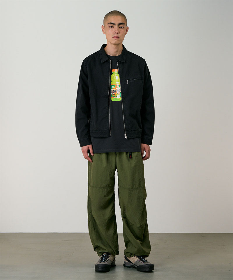 Model wearing olive Gramicci Nylon Paneled Trek Pants and a black jacket on a light-tone background.