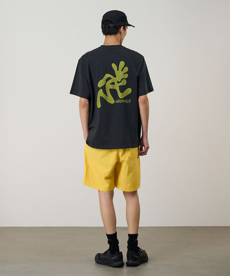 Back view of a model wearing a banana colored Gramicci Nylon Reef Short and a black shirt on a light-tone background.