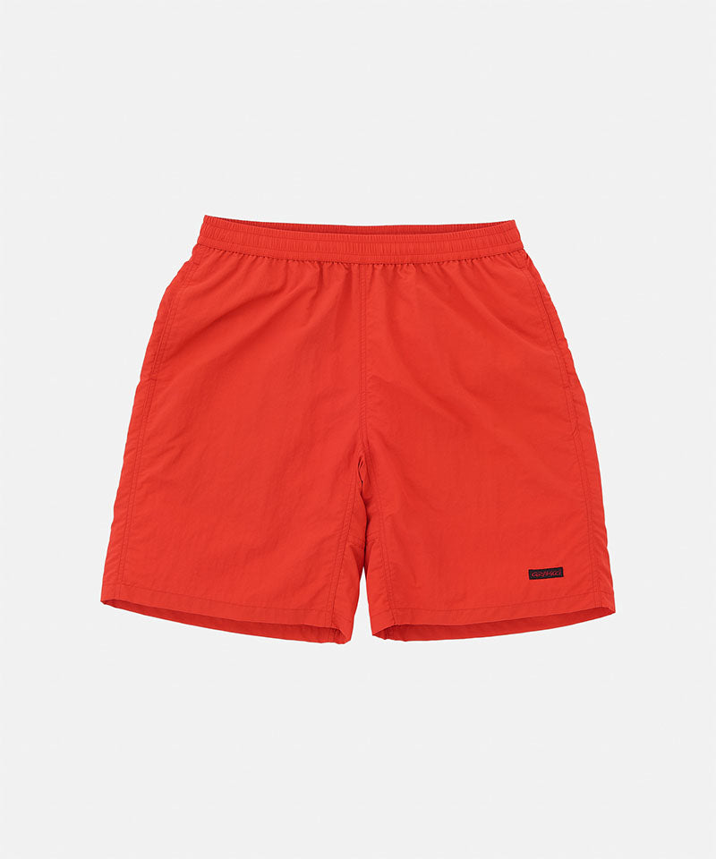 Burnt orange Gramicci Nylon Reef Shorts against a light-tone background.