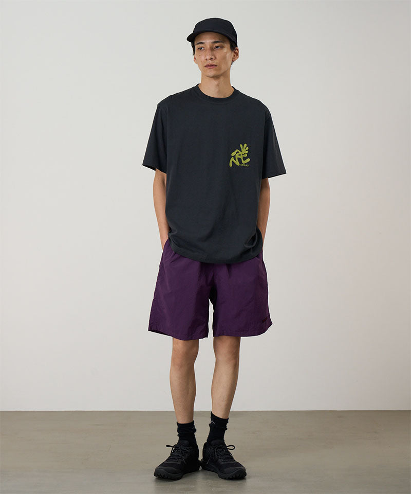 Model wearing deep purple Gramicci Nylon Reef Shorts and a black shirt on a light-tone background.
