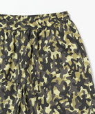 Close-up of the waistband on a olive camo Gramicci Nylon Reef Shorts on a light-tone background.