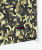 Olive camo Gramicci Nylon Reef Shorts hem showing the logo label on a light-tone background.