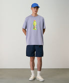 Model wearing british navy Gramicci Nylon Packable G-Shorts and a lavender shirt on a light-tone background.