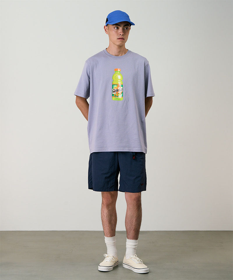 Model wearing british navy Gramicci Nylon Packable G-Shorts and a lavender shirt on a light-tone background.