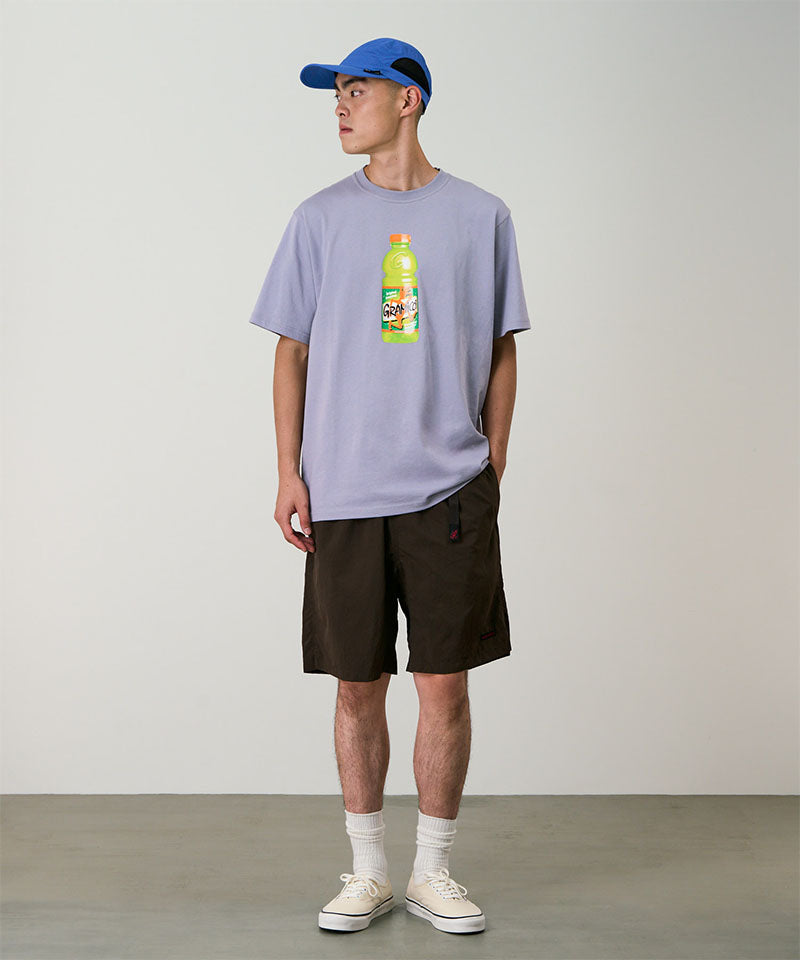 Model wearing chocolate colored Gramicci Nylon Packable G-Shorts and a lavender shirt on a light-tone background.