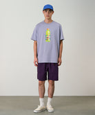 Model wearing deep purple Gramicci Nylon Packable G-Shorts and a lavender shirt on a light-tone background.