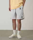 Half Model
Model wearing ecru colored Gramicci Nylon Packable G-Shorts and a mango colored shirt on a light-tone background.