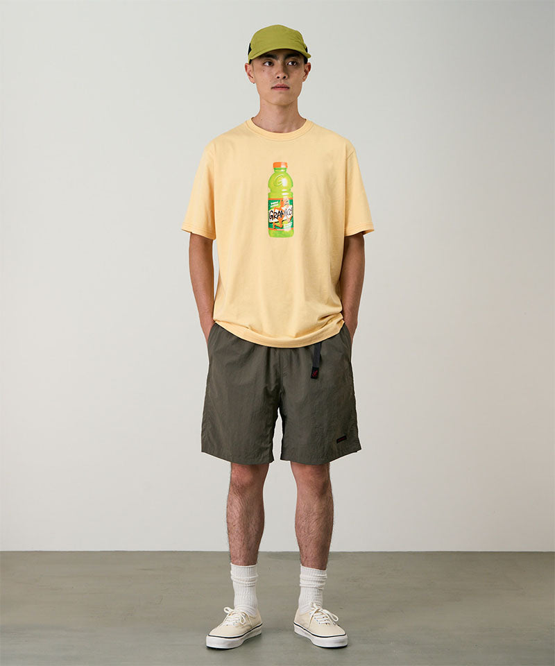 Model wearing granite colored Gramicci Nylon Packable G-Shorts and a mango colored shirt on a light-tone background.